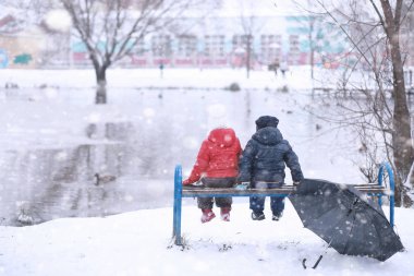 Çocuklar parkta ilk kar yürümek