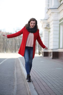 Şehirde kırmızı paltolu bir yolda güzel kız