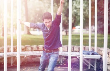 Genç bir adam öğle yemeği zamanında parkta yürür. Bir adam yürüyüşe çıktı. 