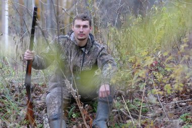 Kamuflaj ve bahar hun üzerinde orman Kuşağı'nda silahlı adam