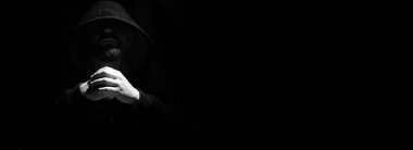 Siyah başlıklı ve yumruklu bir adam.