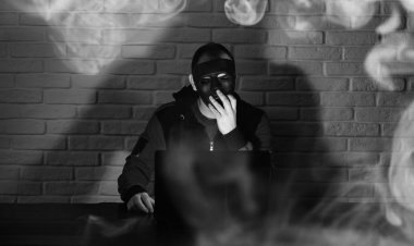 Siyah maske ve hood masada hacker