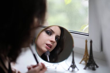 Güzel kız makyaj yapıyor.