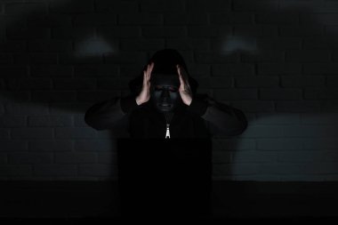 Siyah maske ve hood masada hacker