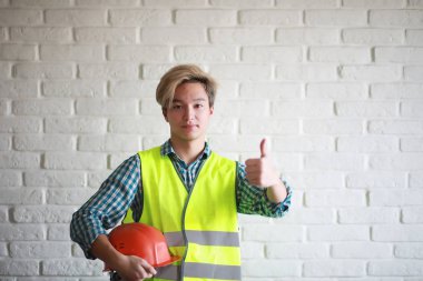 Kask ve inşaat koruyucu yelek Asyalı adam