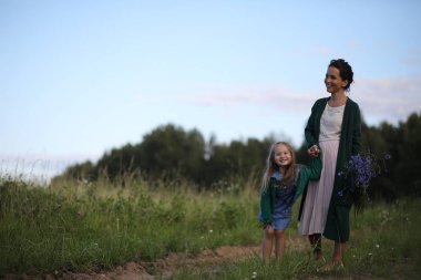 Anne ve kızı yolda yürüyor.