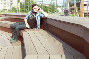 Dışarıda tek başına oturan bir adam var.