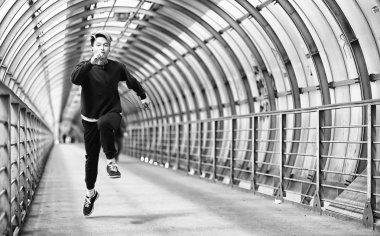 Spor giyimli bir adam açık havada tek renkli fotoğraf çalıştırın