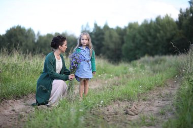 Anne ve kızı yolda yürüyor.