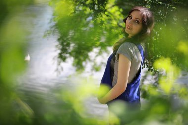 Hamile bir kadın parkta yürüyor.