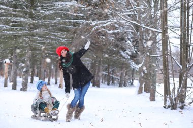 Bir kış masal, genç bir anne ve kızı bir kızak sürmek