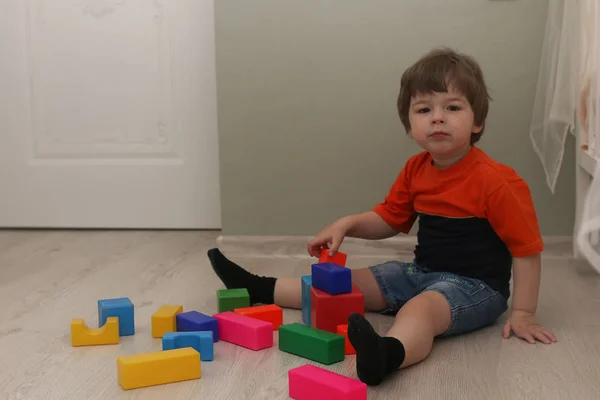 Kleines Kind spielt auf einem Fußboden in einem Raum — Stockfoto