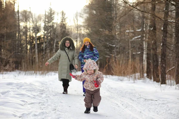 Kid běží v zimním parku a bavte se s rodinou — Stock fotografie