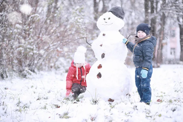 Les enfants marchent dans le parc première neige — Photo