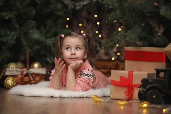 Little girl in new year's Christmas atmosphere. The girl is happ — Stock Photo, Image