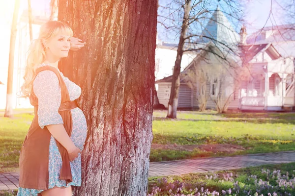 Gravid flicka på en promenad i parken. Flicka med en mage i ci — Stockfoto