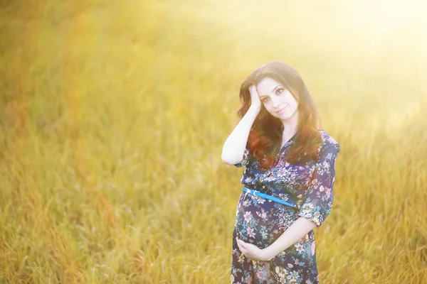 Gravid flicka i en klänning i naturen — Stockfoto