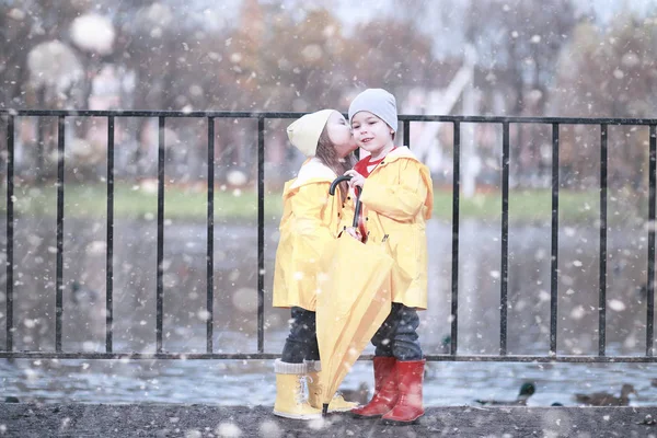 子供たちは公園の最初の雪の中を歩く — ストック写真