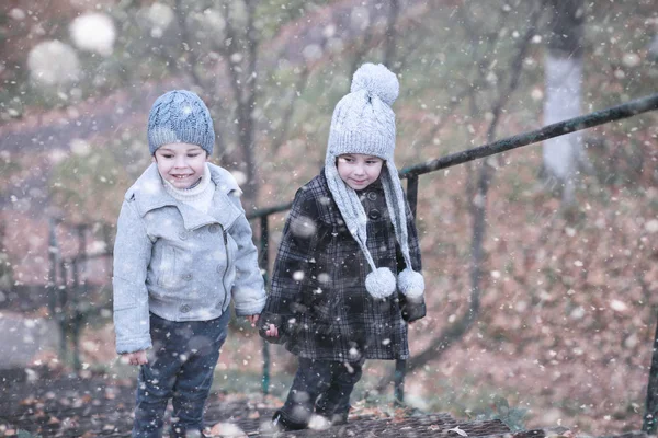 Les enfants marchent dans le parc première neige — Photo
