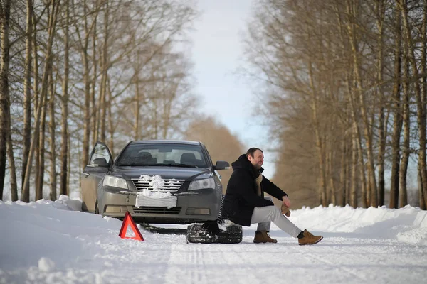 A man near a broken car on a winter day — Stock Photo, Image