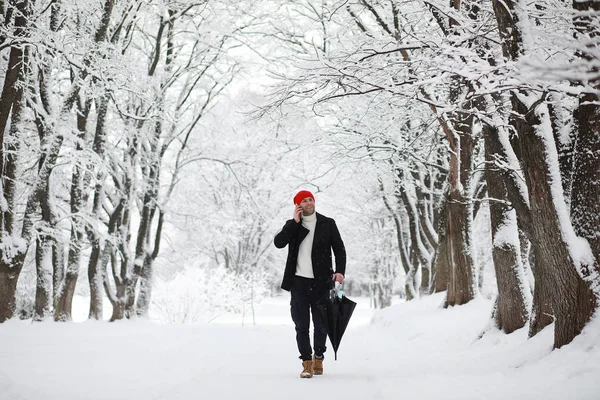 Un hombre en un paseo por el parque. Joven con en el invierno snowfa — Foto de Stock