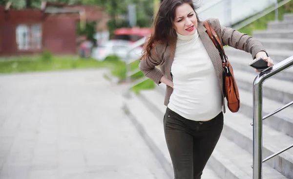 Беременная женщина чувствует боль на улице — стоковое фото