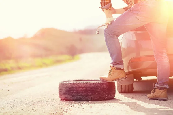 Man sitter på vägen av bilen — Stockfoto