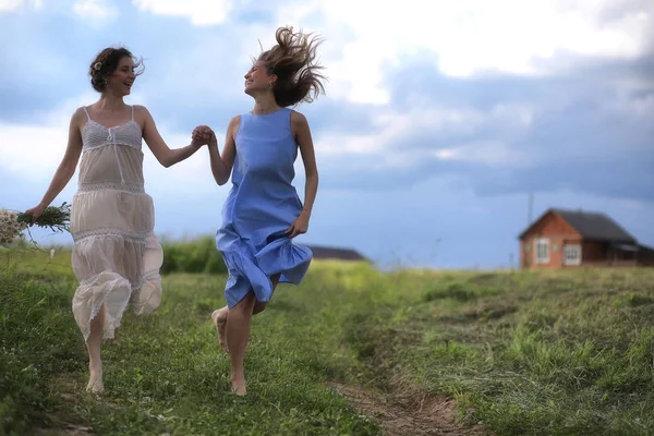 Unga flickor vandrar i fältet — Stockfoto