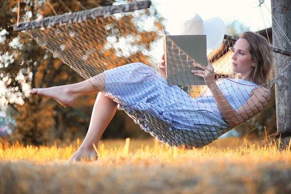 Beautiful girl in hammock reading a book — Stock Photo, Image