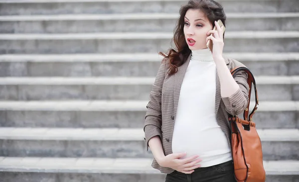 Беременная женщина идет по улице — стоковое фото