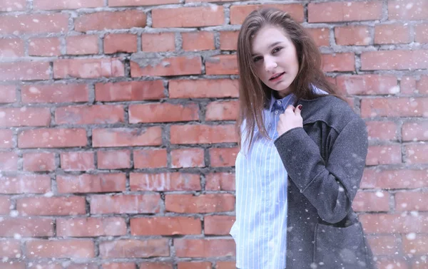 Menina jovem ao ar livre no inverno. Modelo menina posando ao ar livre em um w — Fotografia de Stock