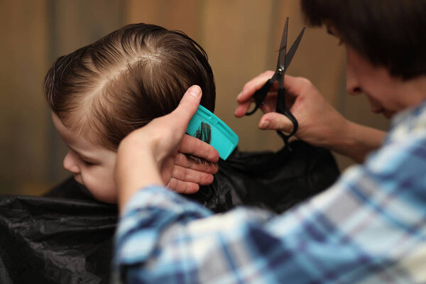A little boy is trimmed in the hairdresser's bright emotions on his fac
