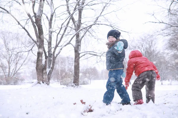 Los niños caminan en el parque primera nieve — Foto de Stock