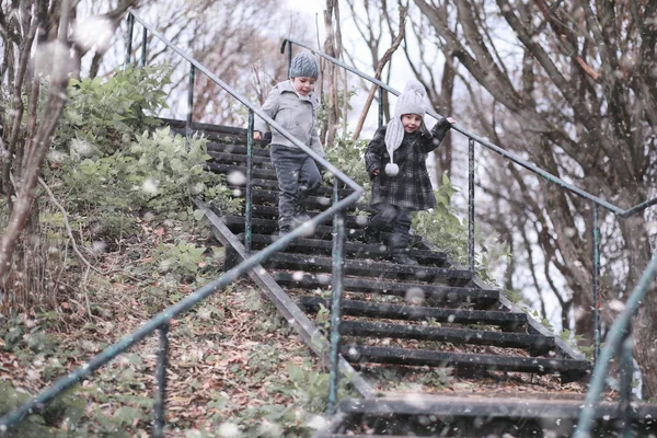 Crianças caminham no parque primeira neve — Fotografia de Stock