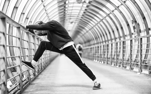 Un uomo in abbigliamento sportivo correre all'aperto foto monocromatica — Foto Stock