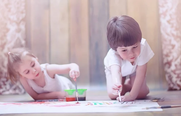 Маленькі діти малюють на великому аркуші паперу — стокове фото