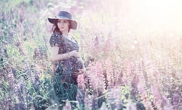 Schwangere auf einem Feld mit Blumen — Stockfoto