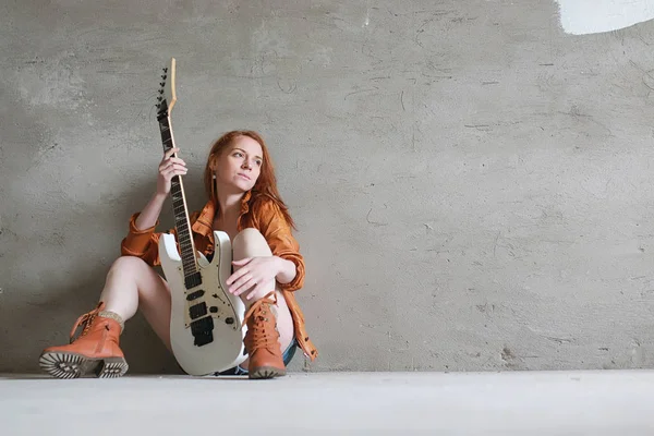 Menina ruiva jovem com uma guitarra elétrica. Músico de rock gir — Fotografia de Stock