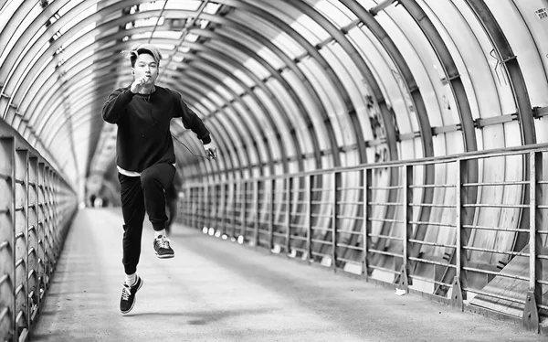 Un hombre en ropa deportiva correr al aire libre monocromo foto — Foto de Stock