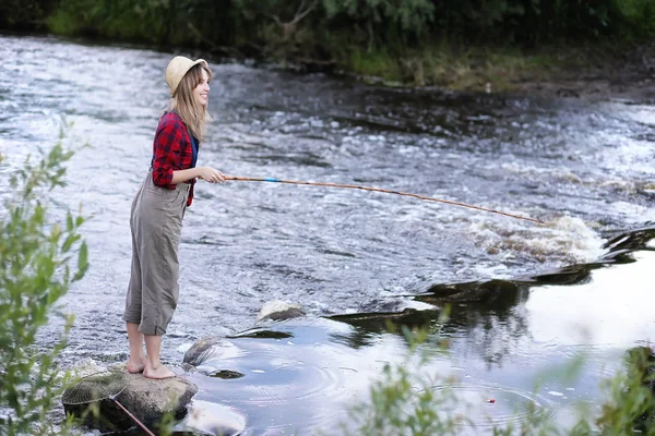 Fille au bord de la rivière avec une canne à pêche — Photo