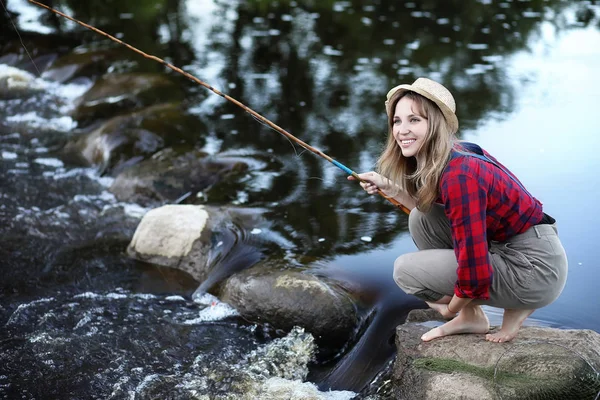 Girl by the river with a fishing rod — Stock Photo, Image