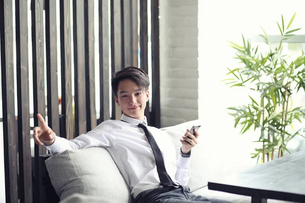 Genç bir Asyalı işadamı bir kafede ortak bekliyor. Bir kafede Koreli genç bir adam telefonda konuşuyor.