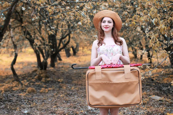 Niña con maleta de cuero para viajar en el parque de otoño a pie — Foto de Stock