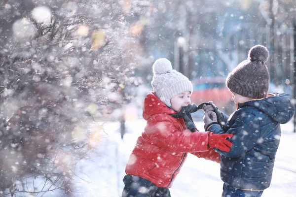 子供たちは公園の最初の雪の中を歩く — ストック写真