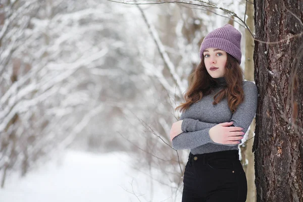 Una joven en un parque de invierno en un paseo. Vacaciones de Navidad en t —  Fotos de Stock