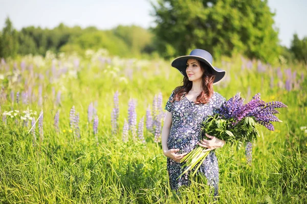 Ragazza incinta in un campo con lupini — Foto Stock