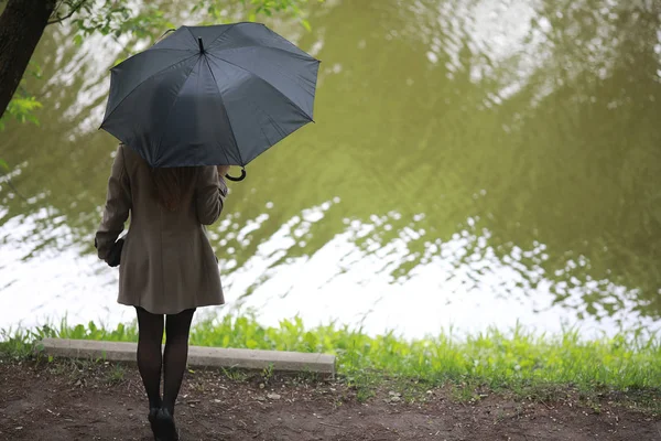 Chica joven en un abrigo en un parque de primavera —  Fotos de Stock