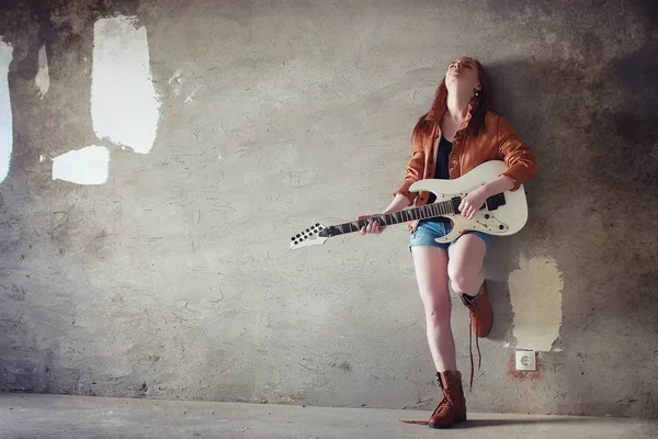 Menina ruiva jovem com uma guitarra elétrica. Músico de rock gir — Fotografia de Stock