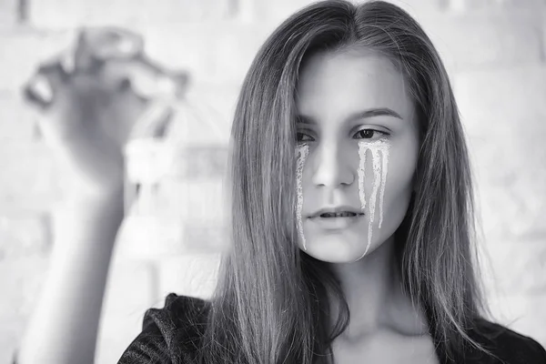 Beautiful girl with tears in her eyes. Young girl with painted t