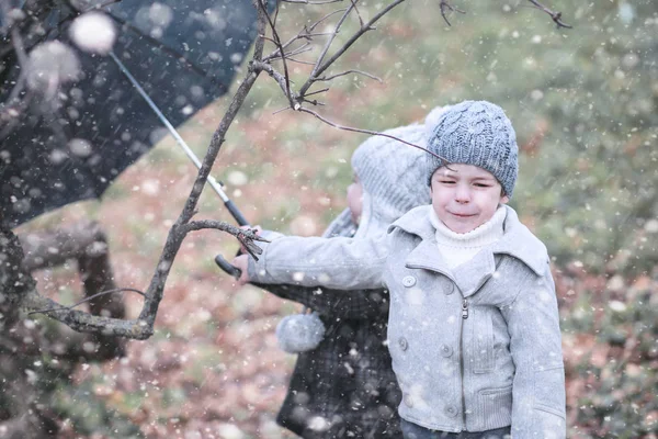 I bambini camminano nel parco prima neve — Foto Stock